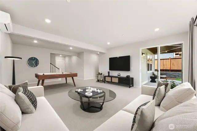 Huge rec room on lower level. Covered patio area. Movie room, playroom, game room, lots of options. Photo of actual home with virtual staging.