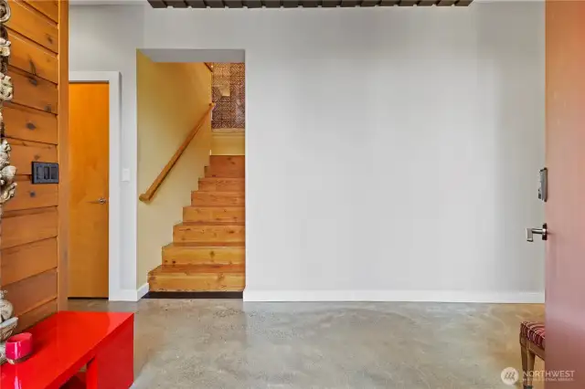 Entry hallway leads to 2nd primary on left, stairs up, laundry & garage (& TONS of storage) to the right