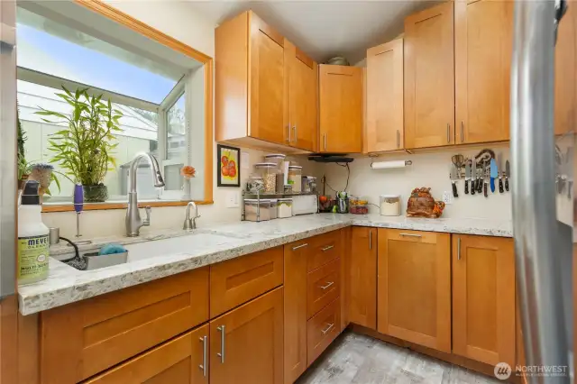 Bright kitchen with solid wood cabinets and plenty of granite counter space and garden window to bring morning sunshine in your kitchen