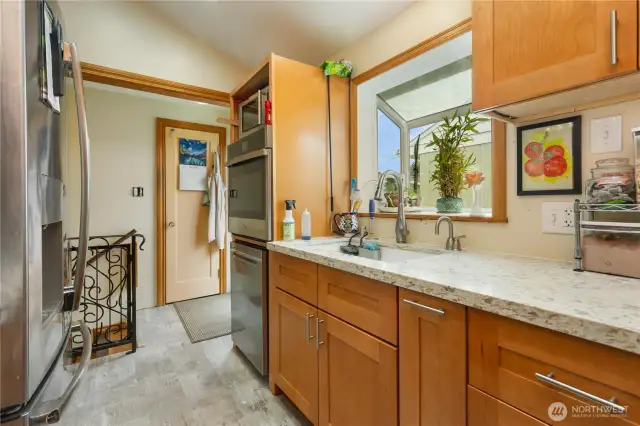 Access view into kitchen with all new flooring wood trim and easy access to back yard barbeques