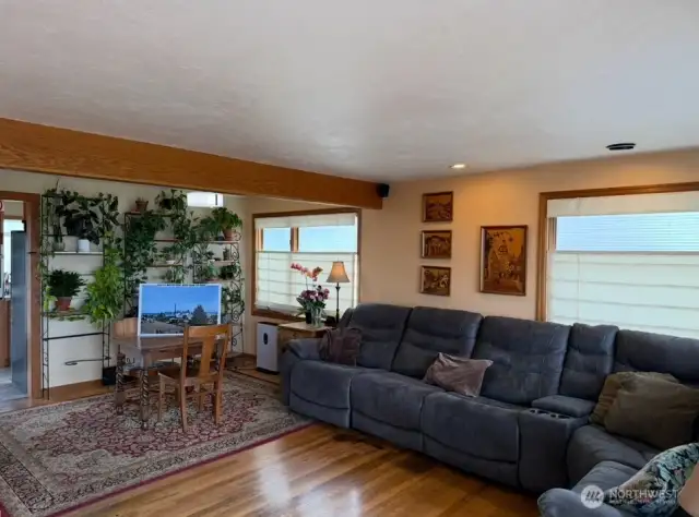 Open-concept living room with french doors lots of large windows facing the views,hardwood flooring with light and bright colors greet you in the happy home