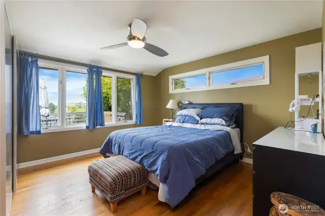 Bright and airy primary bedroom with ceiling fan and large windows. Dont forget more hard wood flooring to enjoy