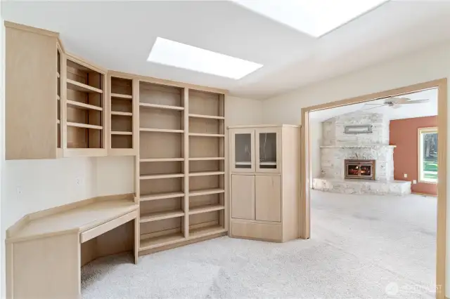 Office off of living room with built in cabinets and bookshelves.
