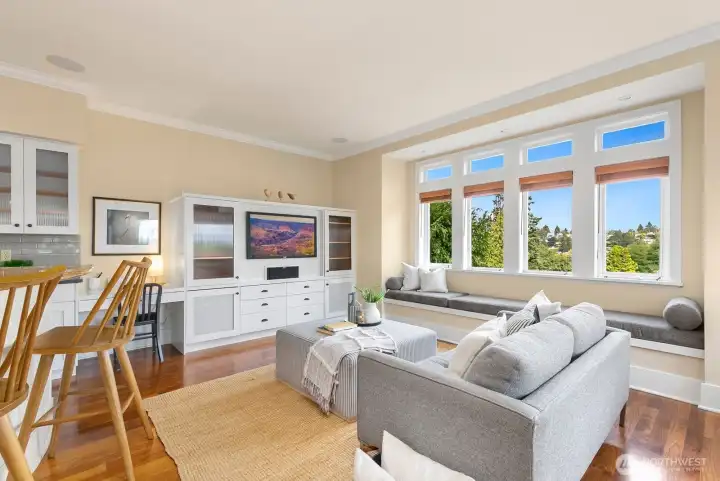 The flex/tv room off of the kitchen is a show-stopper. Lined with east and south facing windows and quite possibly the PERFECT entertaining space. The door to the deck is on the right, not pictured here. Look at that bench seat! So cozy.