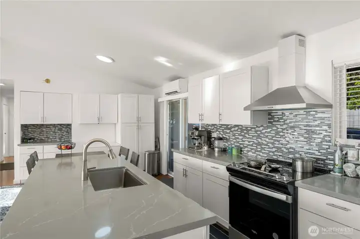 Storage galore in the updated kitchen featuring quartz countertops and stainles steel appliance suite.