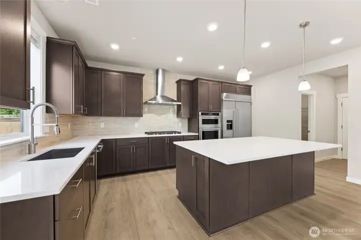 Well-appointed kitchen with gas cooktop, huge pantry adjacent to mud room just off the garage.  48" counter depth side-by-side refrigerator.  Plenty of space to entertain! Cabinet color may be different than actual home.
