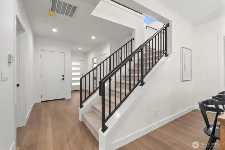 Custom metal staircase railings. All wood look, white plank, LVP floors.