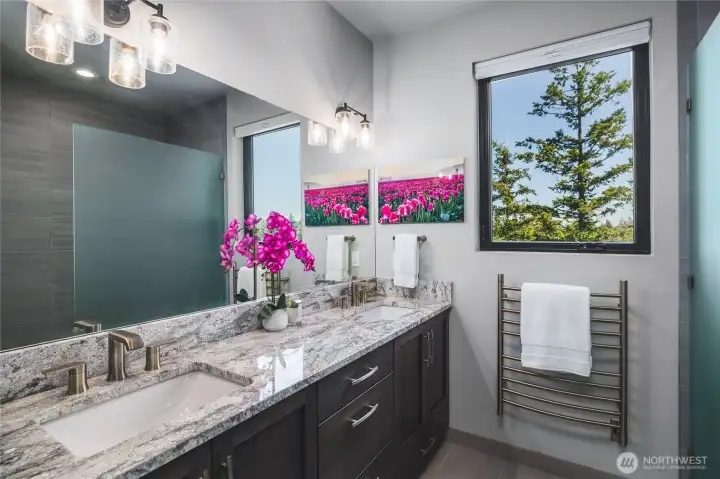 Towel warmer and large window overlooking trees in the primary ensuite bathroom.