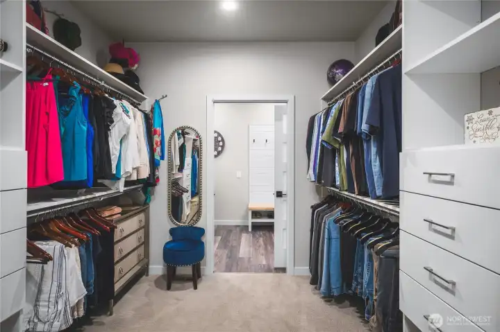 Primary bedroom walk-in closet with custom built-in organizers from Inspired Closets.