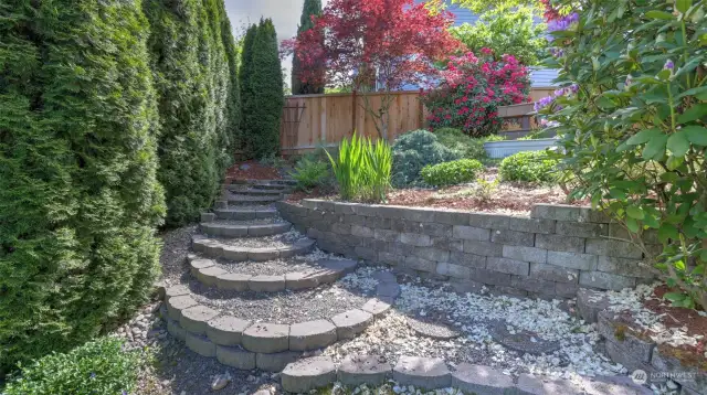 Meticulously selected landscaping throughout this home is perfectly showcased all around with steps & retaining walls to allow space to enjoy the natural beauty throughout.