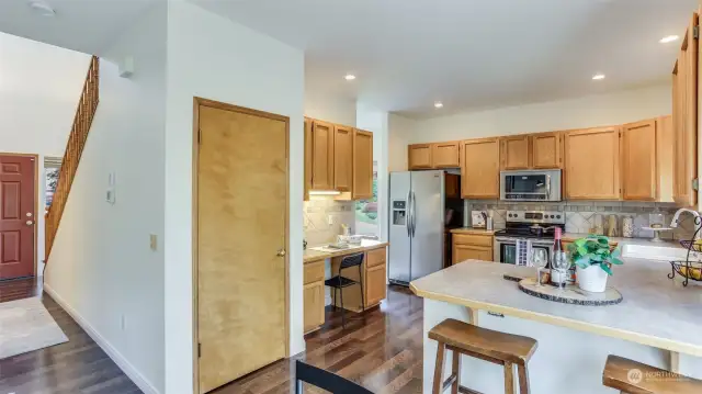 Continuing inside, the stunning engineered hardwoods continue through the kitchen. Kitchen offers convenient breakfast bar seating & spacious walk-in pantry.