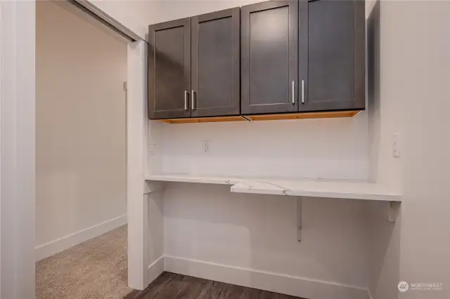 The Utility Room features ample cabinetry for storage, great counterspace for folding laundry and LVP flooring.