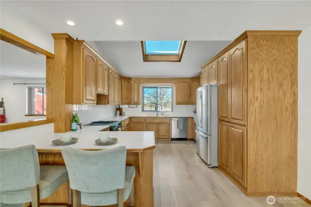 Vaulted kitchen with custom cabinetry & skylight for added natural light.