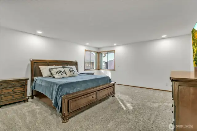 The primary bedroom boasts custom built-in shelving units, a generous walk-in closet, and a 5-piece attached bath.