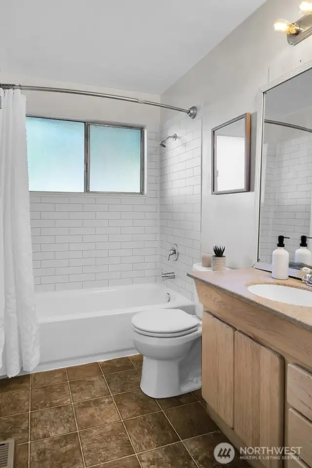 Main bathroom with a brand new tub and classic subway tile surround.