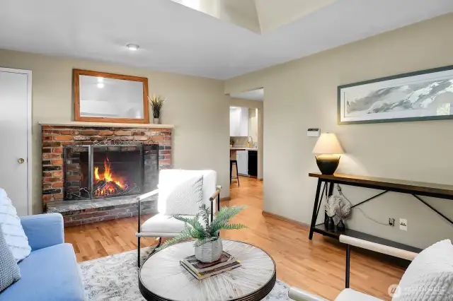 Classic brick fireplace and easy flow into the kitchen.