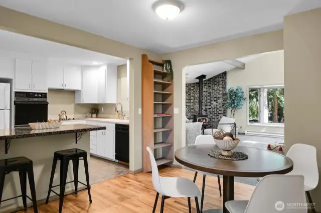 Open kitchen with bar seating and dining nook, flowing into a spacious family room.