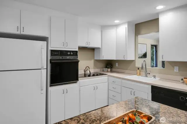 Freshly painted kitchen cabinets with ample storage and a convenient pass-through window.
