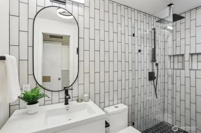 Remodeled bathroom with modern features such as a rainfall shower head.
