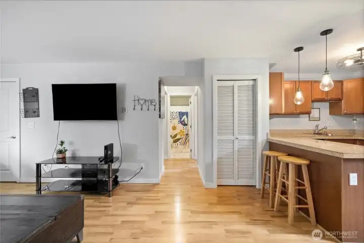 Stacked laundry machines in the closet to the right of the hall.