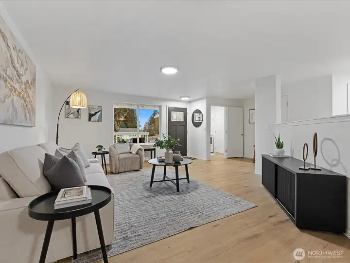 Bright, open living room, featuring wide-plank flooring, large picture window, and flexible layout, ideal for everyday living and entertaining