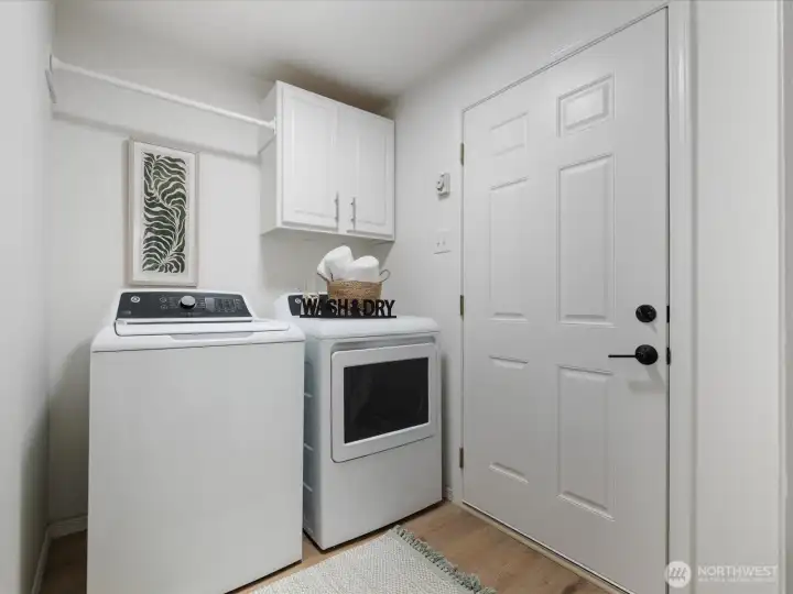 Laundry with new washer and gas dryer off garage, with cabinet space