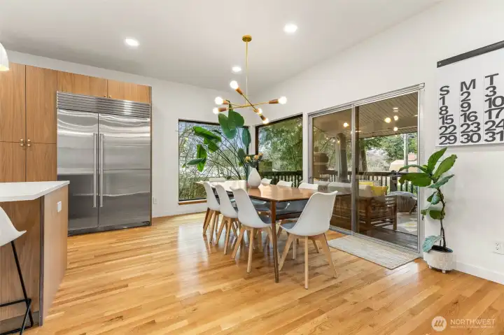 Classic midcentury light fixture above the dining table.  Huge glass slider opens to the covered front porch.
