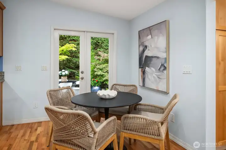 A charming and intimate dining nook bathed in natural light from sliding glass doors to the outdoors creates the perfect casual dining spot, with easy access to the patio for seamless indoor-outdoor living.