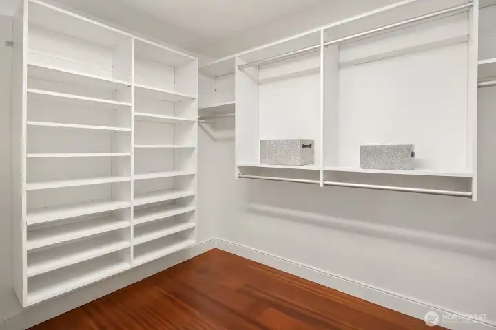 The expansive walk-in closet features custom built-in shelving and hanging space throughout, offering exceptional organization and abundant storage to keep everything perfectly in its place.