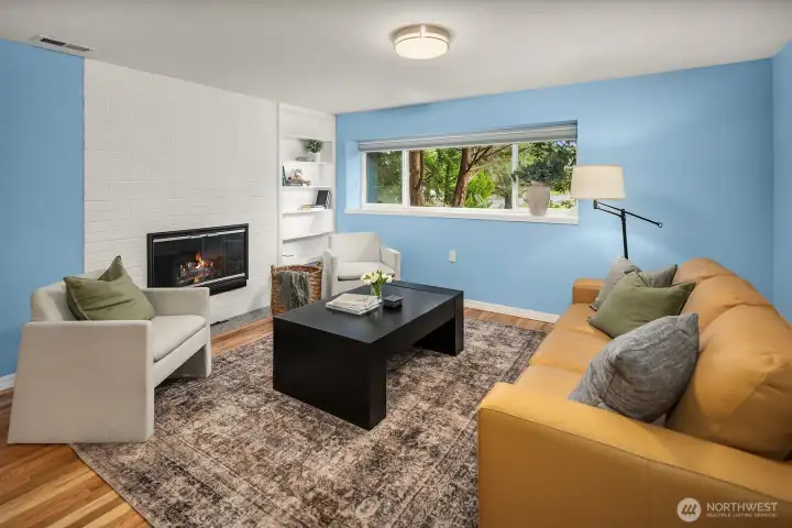 The cozy lower level family room features a fireplace, warm neutral tones, and generous proportions, offering a versatile and comfortable gathering space ideal for guests, movie nights, or relaxed everyday living.
