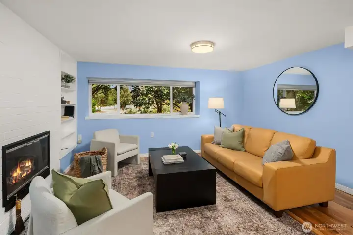 A bright and generously sized lower level room with a cozy fireplace offers incredible flexibility, ideal as a guest suite, home office, or additional family room to suit any lifestyle need.