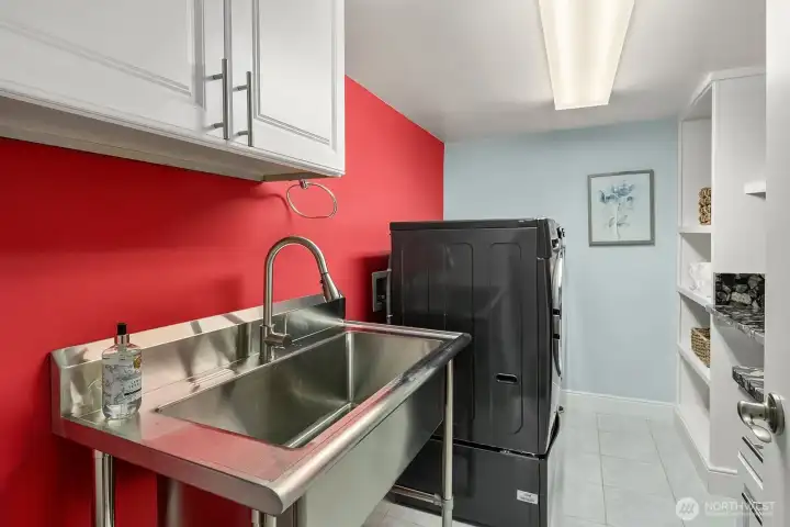 A unique and functional bonus space features a utility sink, ample cabinetry, and dedicated storage, perfect for use as a wine cellar, hobby room, or additional workspace to complement this exceptional home.