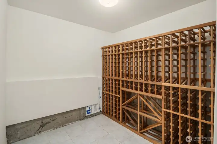 A wine enthusiast's dream, this dedicated wine cellar features custom wood racking with impressive storage capacity, offering the perfect temperature-controlled space to house and showcase your collection.