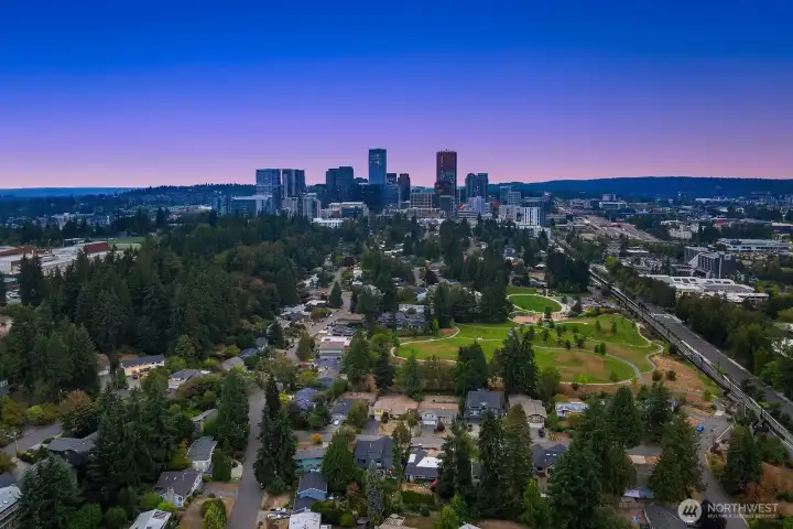 A breathtaking twilight aerial showcases the home's prime Surrey Downs location with the glittering downtown Bellevue skyline as a backdrop, the perfect reminder that urban conveniences, top-rated schools, and neighborhood charm are all just moments away.