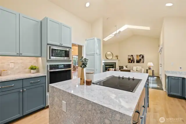 Beautifully remodeled kitchen with walk-in pantry, quartz countertops, plenty of cabinetry, stainless appliances and hardwood floors flows seemlessly into the family room.  This is a one story rambler; so you could add a hood vent over the range quite easily if desired.