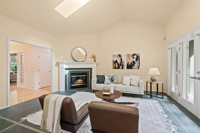 Family room off the kitchen with slate floors, gas fireplace, vaulted ceilings, skylight and French doors open to the backyard deck and large level backyard.