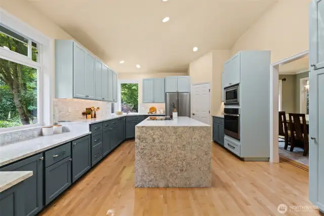 Family room off the kitchen with slate floors, gas fireplace, vaulted ceilings, skylight and French doors open to the backyard deck and large level backyard.