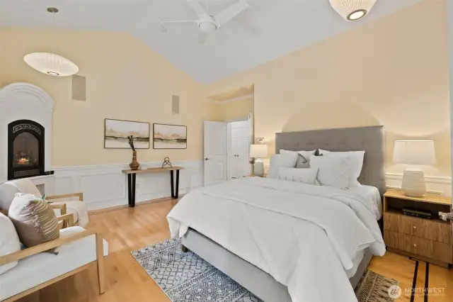 Primary bedroom with vaulted ceiling and hardwood floors.