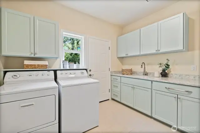 Laundry room with quartz counters and plenty of cabinetry conveniently located off the garage.