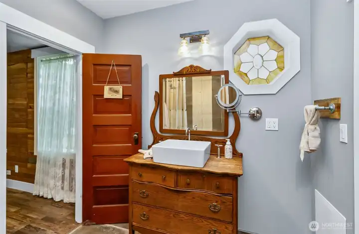 Main floor 3/4 bath speaks of the 1880's era.  Love the stained glass window! Jack & Jill entry from both bedroom 1 & 2.