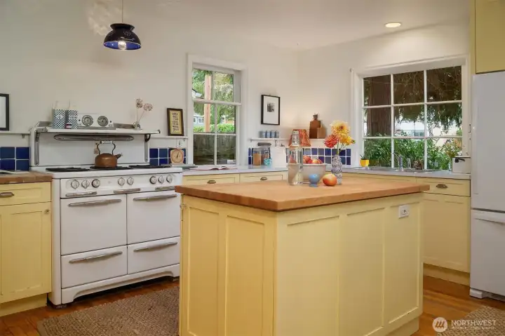 An epic kitchen that is all farmhouse meets modern design. The stunning stove is the star of the show. And the double sinks and double storage are the workhorses for daily life.  The butcher block island for is perfect for serving, prepping and hanging out. And it hides a dishwasher.