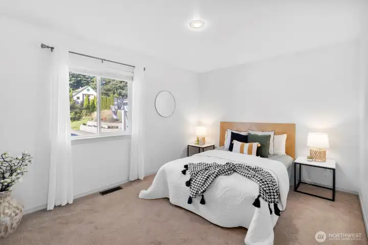 Peaceful primary bedroom with abundant natural light.