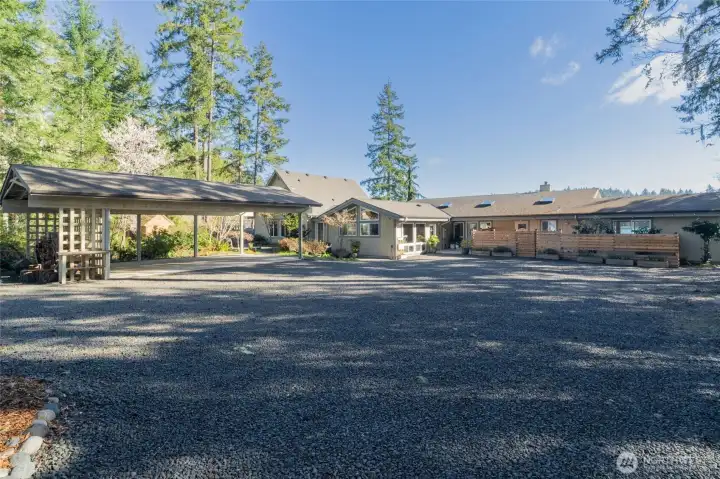 This property boosts a main home (on the right), a guest house (left, center) and a natatorium that connects the two that has a swim spa, hot tub, and infrared sauna.  Lots of room to park, including a 3 car carport.