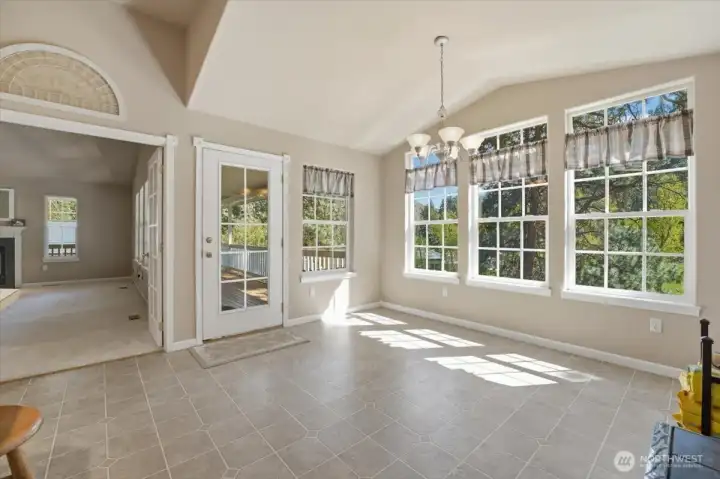Dining room with lots of windows. Looking towards living room and door to the wrap-around deck.