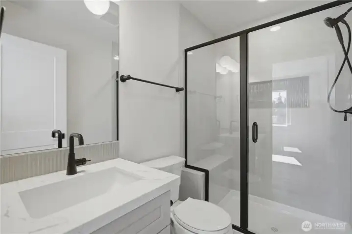 Primary bath with quartz vanity and modern fixtures