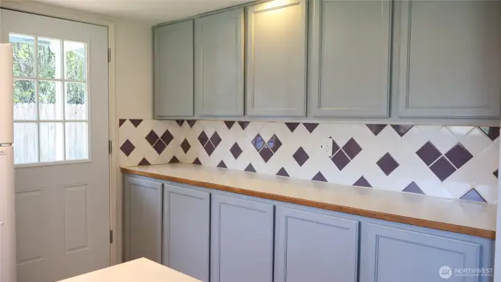 Entire wall of cabinets and full size counter top allows kitchen use to expand.