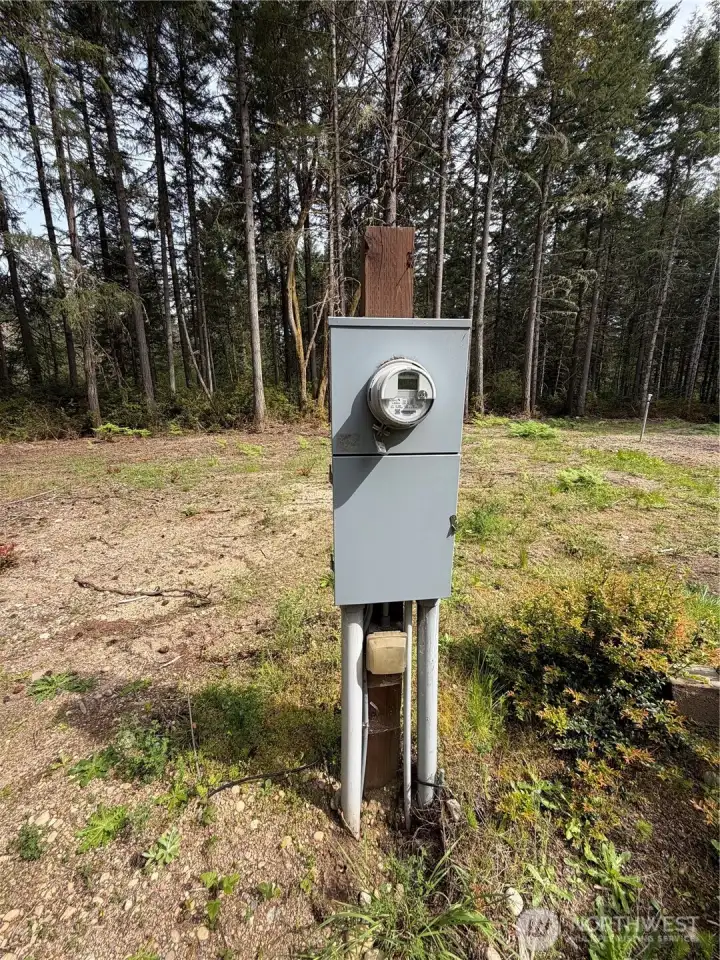 The utility meter is already installed and active at the center of the lot. Power is live and accessible.