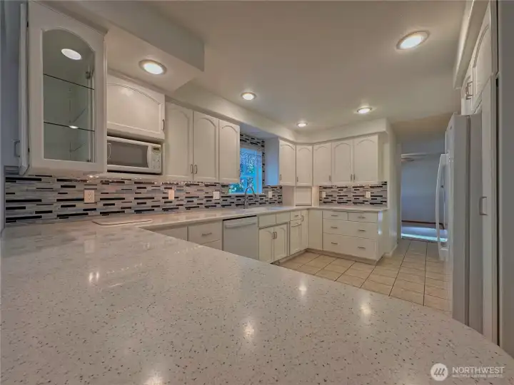 A beautifully remodeled kitchen is designed for both function and style, featuring Corian countertops.