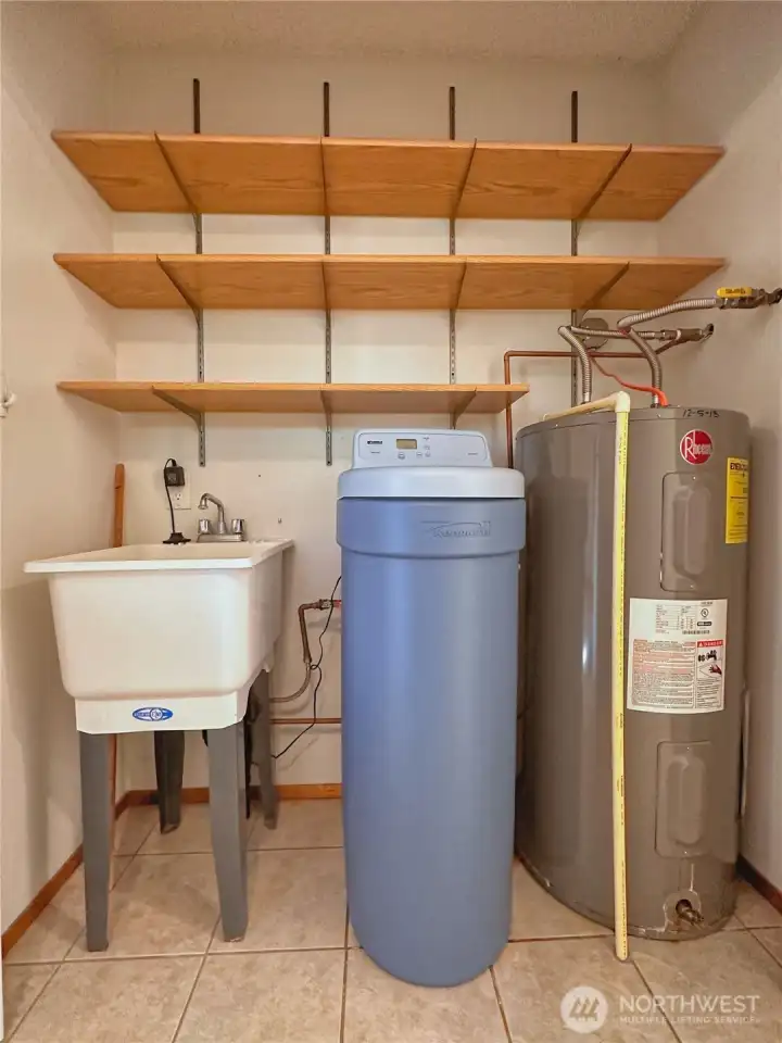 Utility closet off kitchen/laundry room with water softener (owned).
