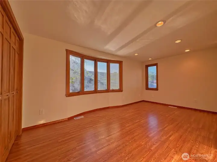 Large guest bedroom on north side of home with bow style window is great for a private office space or separate guest space.